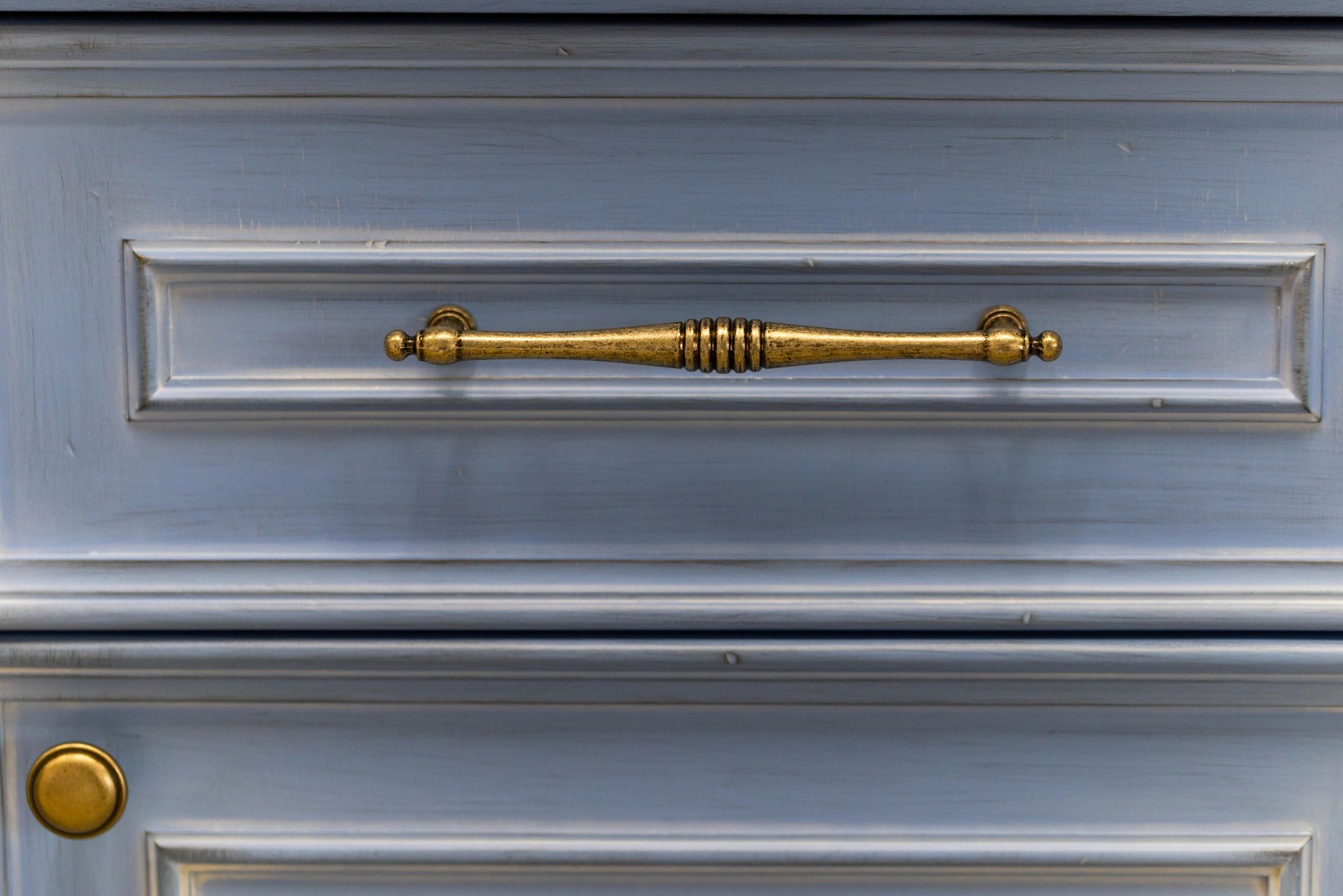 Close-up of cabinet handle detail in a warm metallic finish